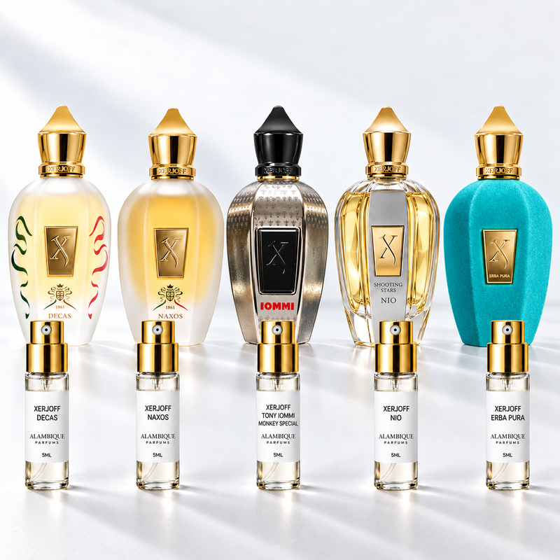 Xerjoff Discovery Set: cinco decants Alambique de Decas, Naxos, Tony Iommi Monkey Special, Nio y Erba Pura, con etiquetas blancas y atomizadores dorados. Botellas originales al fondo como referencia, no incluidas.