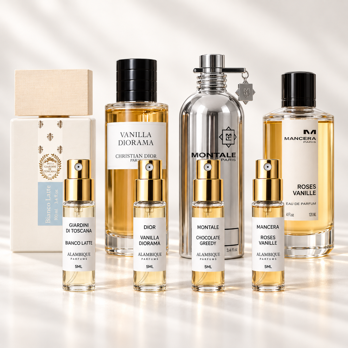 Vainilla & Gourmand Discovery Set: cuatro decants con etiquetas blancas; botellas originales al fondo solo como referencia.