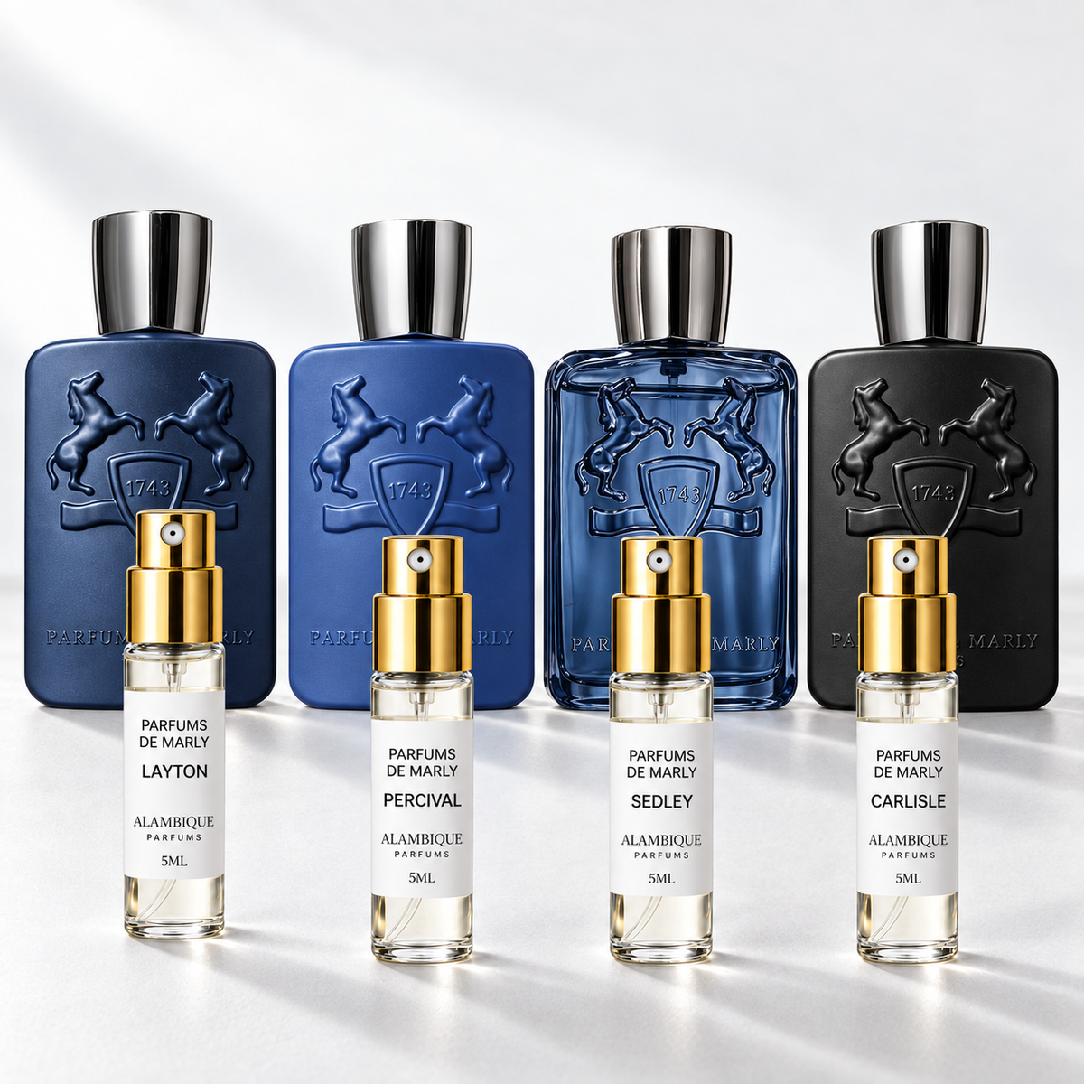 Parfums de Marly Discovery Set: cuatro decants de etiqueta blanca frente a las botellas de referencia; las botellas originales no están incluidas.